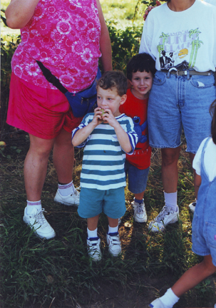 Louis eats an apple while David Levy looks on (Jill & Rhonda Levy above)