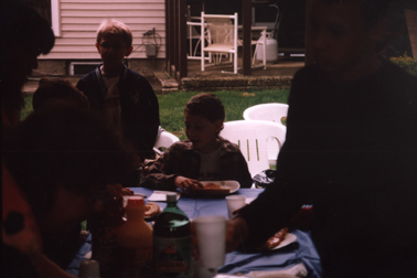 Louis at head of table surrounded by friends