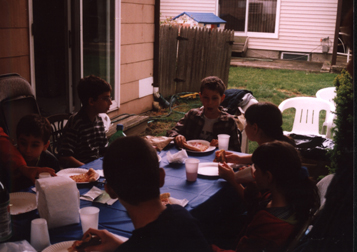 Louis at head of table surrounded by friends